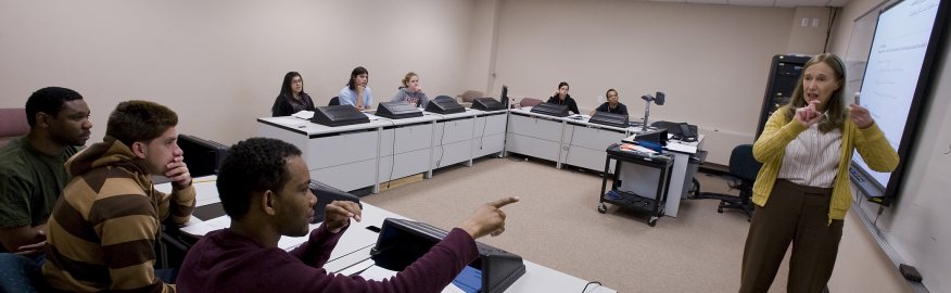 A picture of a professor signing to a classroom of students